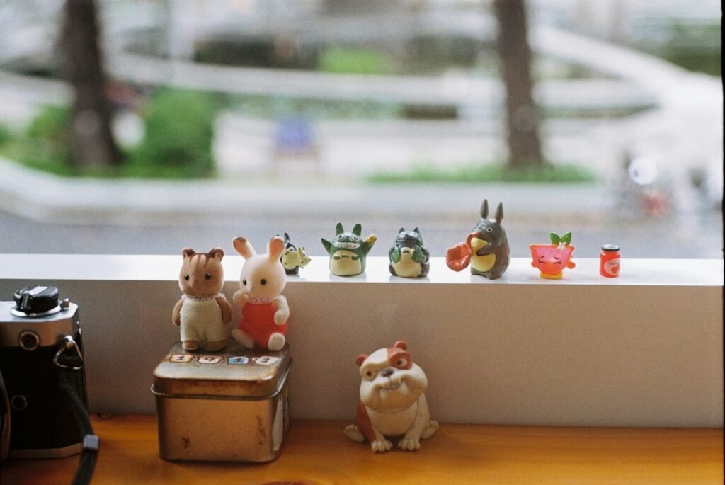 A whimsical arrangement of toy figurines on a window shelf, perfect for decor inspiration.