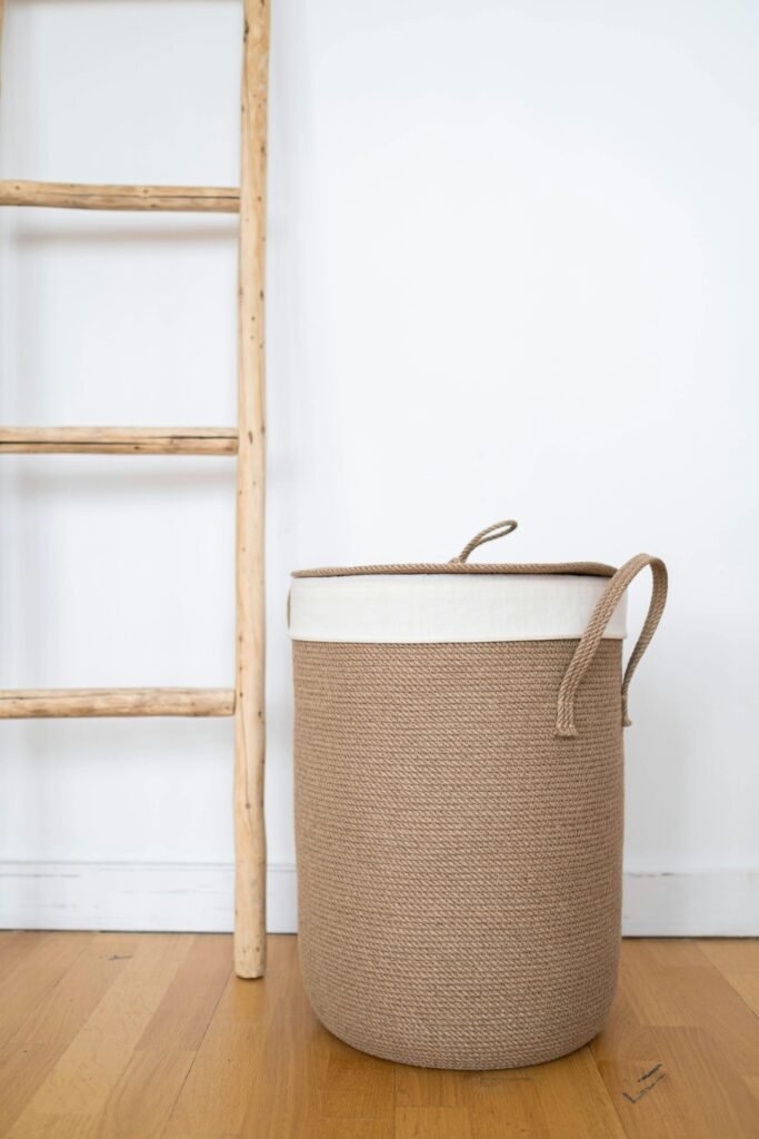 Stylish wicker laundry basket in a modern, minimalist room with wooden ladder accents.
